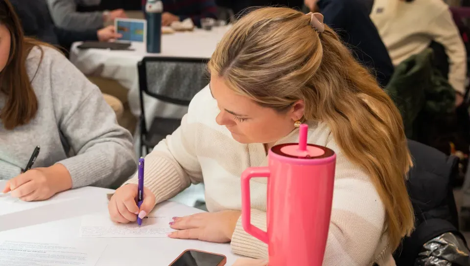 A student writes a postcard