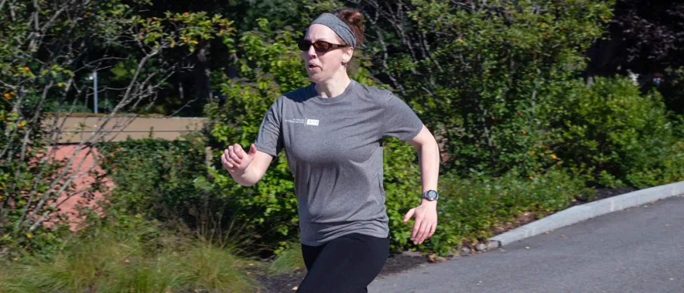 U N E employee jogging on the Biddeford Campus